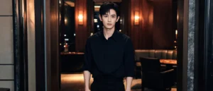 身穿深黑襯衫的年輕男性站在暖橘燈光的包廂通道，示意男模會館與男傳播兩種夜間消費場景的差別